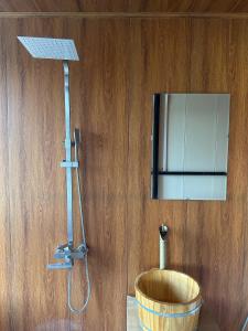 y baño con ducha y pared de madera. en NaNa Farm, en Bak Kan