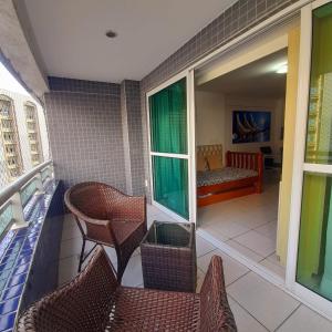 a balcony with chairs and a couch in a room at Beach Class Rosalux 707 in Fortaleza +23 photos
