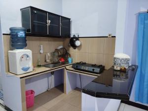 a small kitchen with a sink and a stove at Bromo Jay House Homestay I in Sukapura