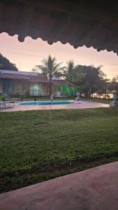 a building with a pool and palm trees in the distance at Pousada Bella Vista in Delfinópolis