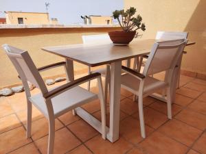 una mesa de madera con 2 sillas y una maceta en ella en Casa Helios - Precioso ático con sol, mar y relax, en Aguadulce