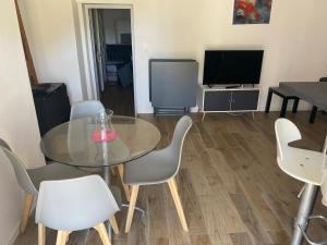 a dining room with a table and chairs and a television at Casa Padulella (4 appartements) in Moriani Plage