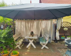 a table and two chairs under a black umbrella at MAYA apartament in Jantar +5 photos