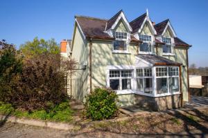 Casa blanca con ventanas y valla en Langton Farmhouse Fishguard, en Fishguard
