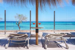 two chairs and a table in front of the ocean at Caprice Concord Hotel & Spa in Can Picafort