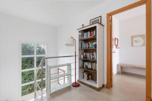 een kamer met een boekenplank en een raam bij Villa Tres in Es Mercadal