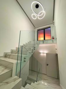 a glass staircase in a white room with a window at Hotel Egitarso in San Vito lo Capo +17 photos