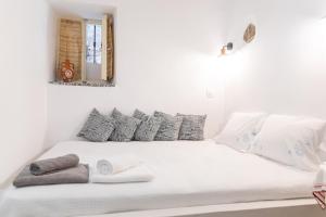 a white bed with towels and a mirror on the wall at Parakathi Mesta in Chios