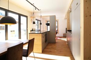 a kitchen with a table and a dining room at LEHNER Panorama Alpensuiten in Berwang