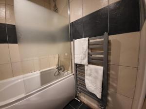 a bathroom with a tub and a shower with towels at 2 bed flat Centre Swansea in Swansea