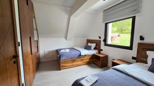 a bedroom with two beds and a window at Durmitor Summit in Žabljak