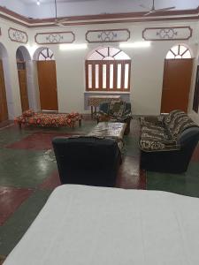 a living room with couches and tables and windows at Topper stay in Varanasi
