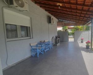 a patio with blue chairs and a table and a window at Villa Katerina in Polykárpion