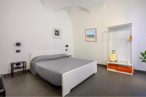 a white bedroom with a bed and a window at Sotto la Mansarda Apartament in La Spezia