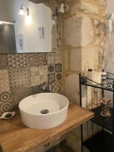a bathroom with a white sink on a wooden counter at Corte Sicula in Syracuse +27 photos