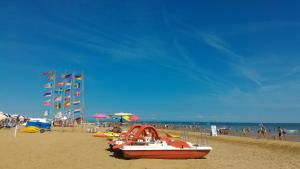 a boat on a beach with a crowd of people at Appartamenti La Quercia in Bibione +5 photos