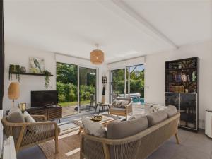 ein Wohnzimmer mit Sofa und Fernseher in der Unterkunft Piscine chauffée - 750m plage - 4 adultes - 4 enfants in Saint-Vincent-sur-Jard