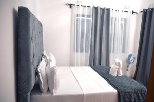 a bedroom with a bed with two stuffed animals on it at Smooth apartments and tours in Livingstone