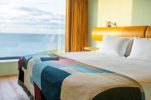 una camera da letto con un letto con vista sull'oceano di SeaSpace a Newquay