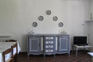 5 Lands Stone Cottage في ليفانتو: خزانة ملابس زرقاء في غرفة مع لوحات على الحائط
