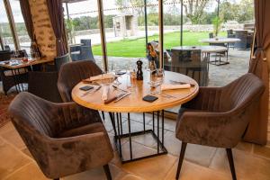 a table in a restaurant with chairs around it at Mas De Baumes in Ferrières-les-Verreries