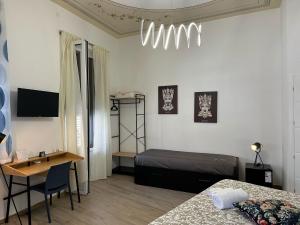 Un dormitorio con una cama, un escritorio y una mesa. en Palermo Mia, en Palermo