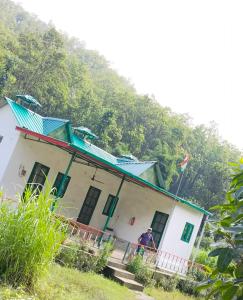 een man die voor een wit huis staat bij Corbett hill center river home stay in Lansdowne