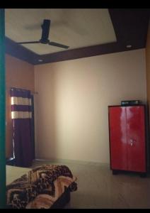 een slaapkamer met een plafondventilator en een bed bij Corbett hill center river home stay in Lansdowne