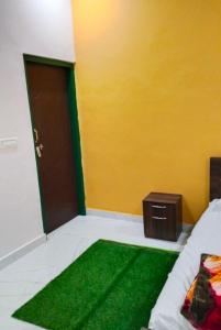 een kamer met een groen kleed naast een deur bij Corbett hill center river home stay in Lansdowne +9 foto's