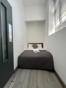 a bedroom with a bed in a white room at Modern 2bed warehouse conversion apartment for 6 people - London in London