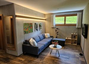 a living room with a blue couch and a table at Chesa Bunita Trais in Gaschurn