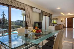 a living room with a glass table with a bowl of fruit at Luxury Villa Amaltheia Rhodes in Koskinou