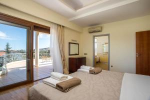 a bedroom with two beds and a balcony at Luxury Villa Amaltheia Rhodes in Koskinou +55 photos