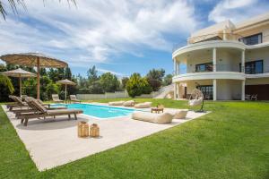 a villa with a swimming pool and a house at Luxury Villa Amaltheia Rhodes in Koskinou