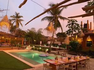 a resort with a pool and a table with drinks on it at CAJOU LODGE in Bubaque