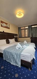 a hotel room with two beds with towels on them at La Dolce Vita in Braşov