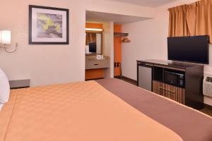 Cette chambre comprend un lit et une télévision à écran plat. dans l'établissement Americas Best Value Inn Ponca City, à Ponca City