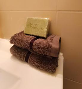 a pile of towels sitting on top of a toilet at Entre montagne et lavande - Maison Provençale in Saint-Étienne-les-Orgues