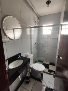a bathroom with a toilet and a sink and a mirror at Pousada Tiriri Guesthouse in Barra do Camaragibe