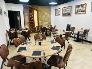a dining room with tables and chairs in a restaurant at Hôtel L'Acropole in Nissan-lez-Enserune
