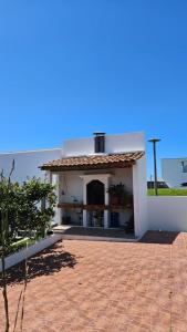 a small white building with a brick patio at Apartamento Terra e Mar II in Ponta Garça