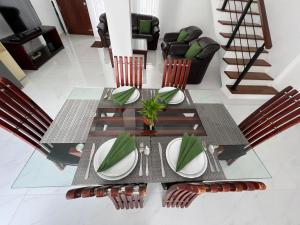a dining room table with chairs and plates on it at Tranquara Battaramulla - 3 mts walking to Overseas School of Colombo in Battaramulla