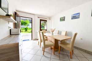 a kitchen and dining room with a wooden table and chairs at House Turkalj in Grabovac