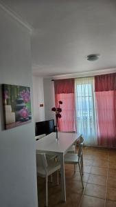 a dining room with a white table and chairs at Apartamento Terra e Mar II in Ponta Garça