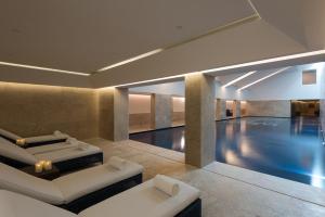 a pool room with two beds and a swimming pool at NAU Palacio do Governador in Lisbon