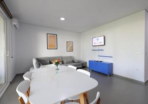 a white room with a table and chairs and a couch at Gjiri i Lalzit - San Pietro - Leta's Apartments with Garden in Lalzit Bay