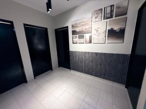 a bathroom with black doors and a tile floor at Babania Spice Stay in Bayan Lepas
