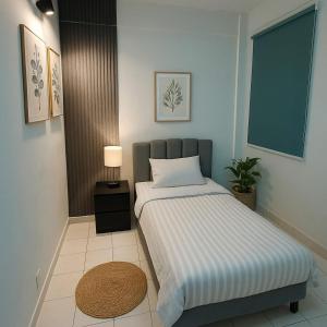 a small bedroom with a bed and a nightstand with at Babania Spice Stay in Bayan Lepas