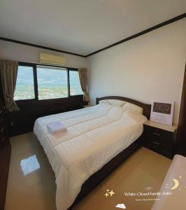 a bedroom with a large bed with a large window at White Cloud Family Suite in Hat Yai +8 photos