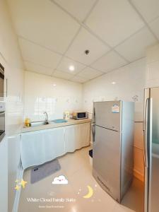 a kitchen with a refrigerator and a sink at White Cloud Family Suite in Ban Kohong